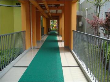 上海临港新城海音幼儿园整洁的走廊，贴心的防滑毯让宝宝在下雨天也不怕会滑倒